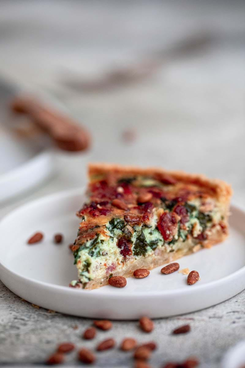 Close-up shot of one slice of the spinach bacon quiche.