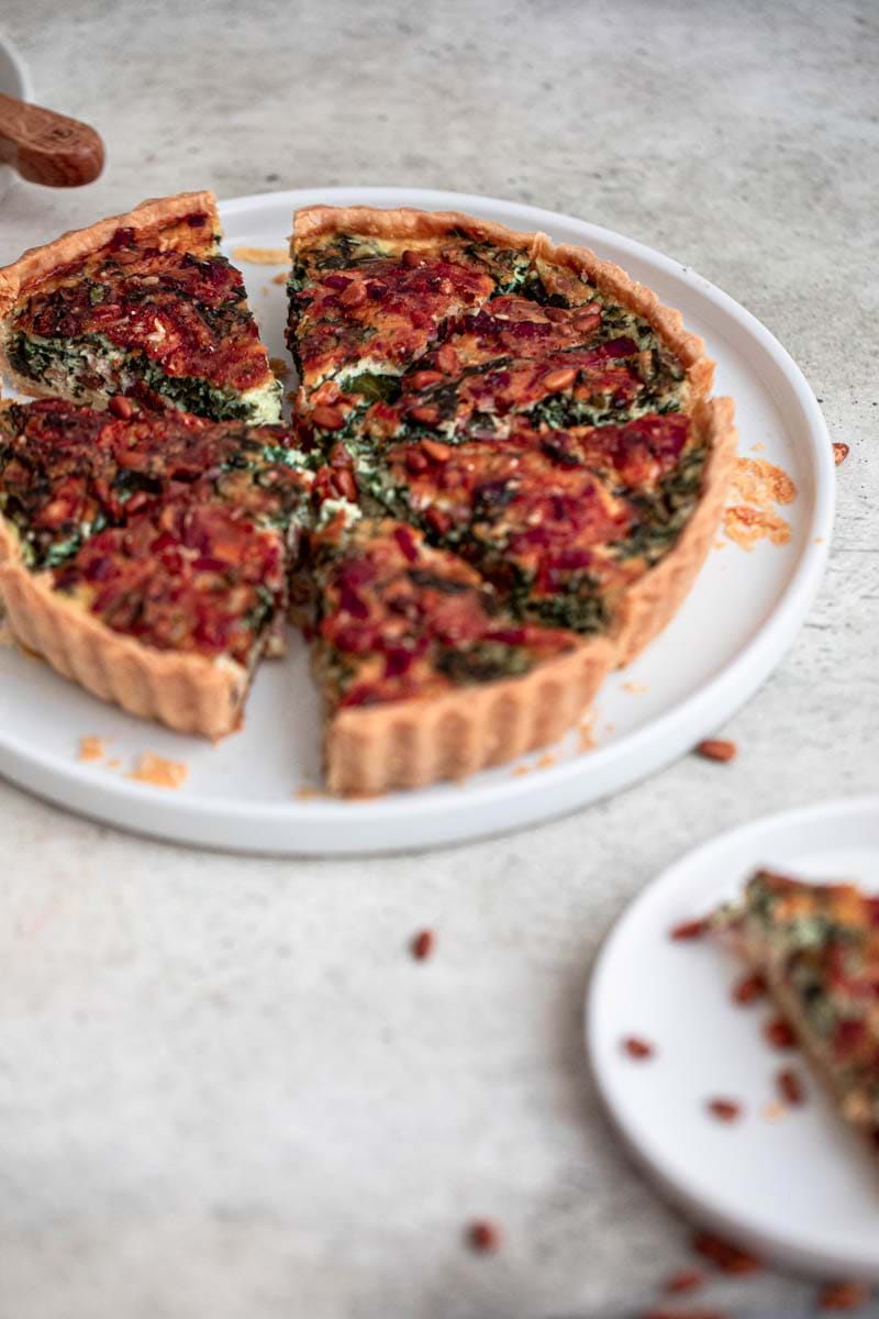 45° shot of the whole spinach bacon quiche sliced.