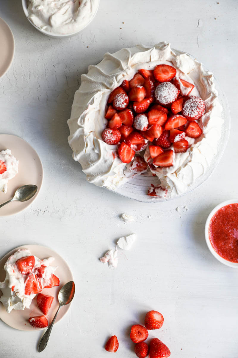 Overhead shot of the pavlova with one slice served on a small plate