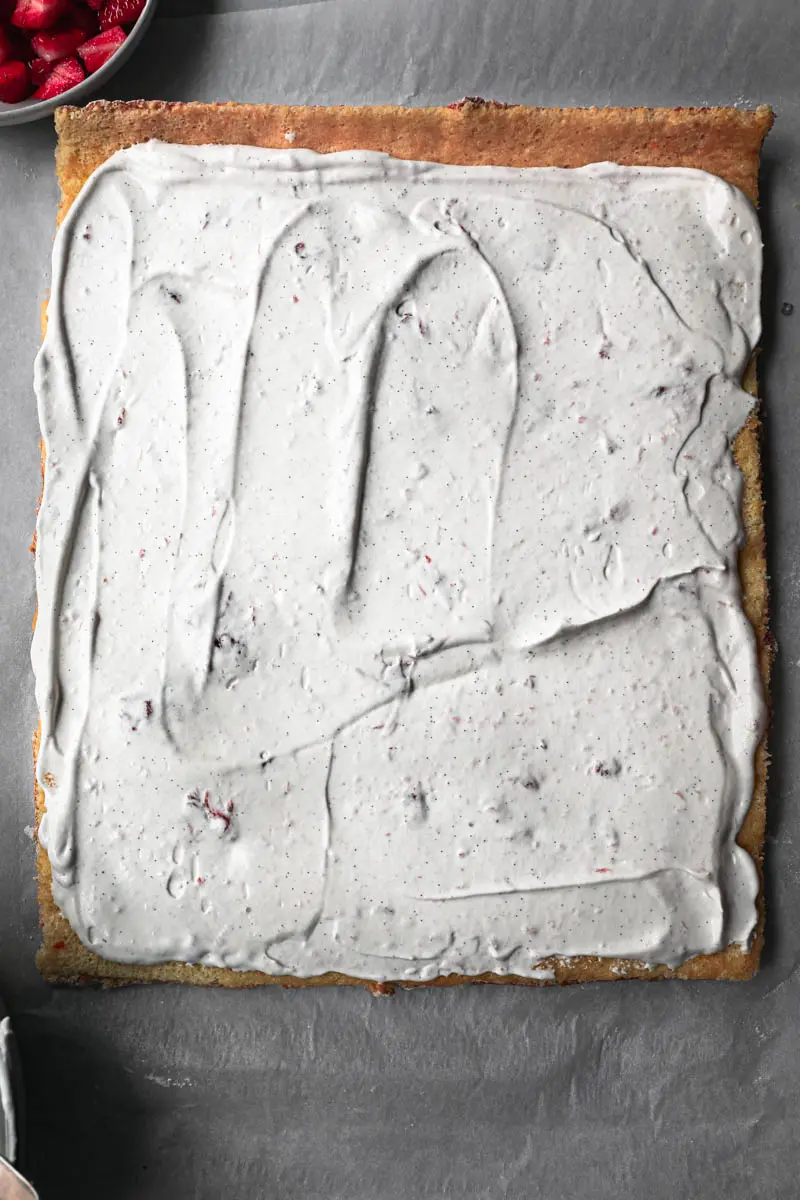 The roll cake unrolled covered with strawberry Chantilly cream.