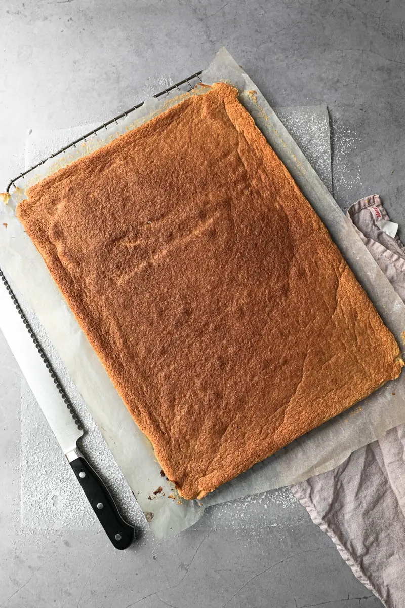 The roll cake just baked on a wire rack.