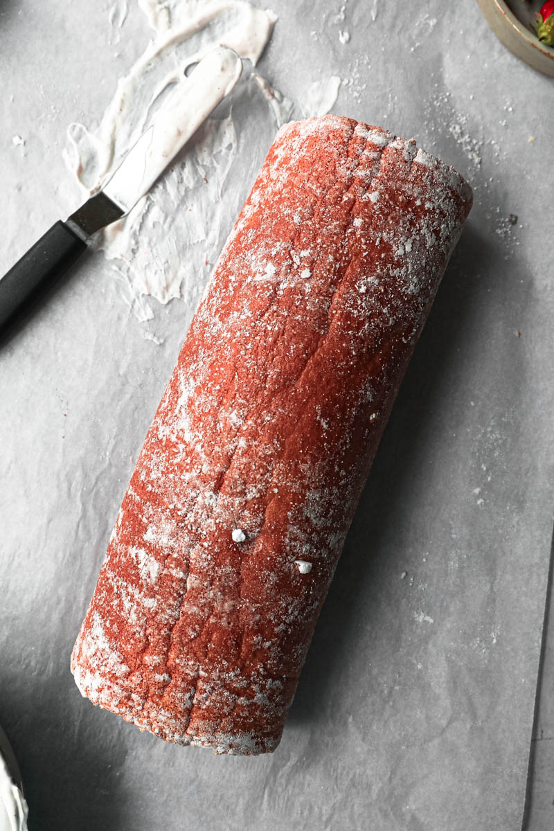 The rolled cake as seen from above with a small offset spatula on the side.