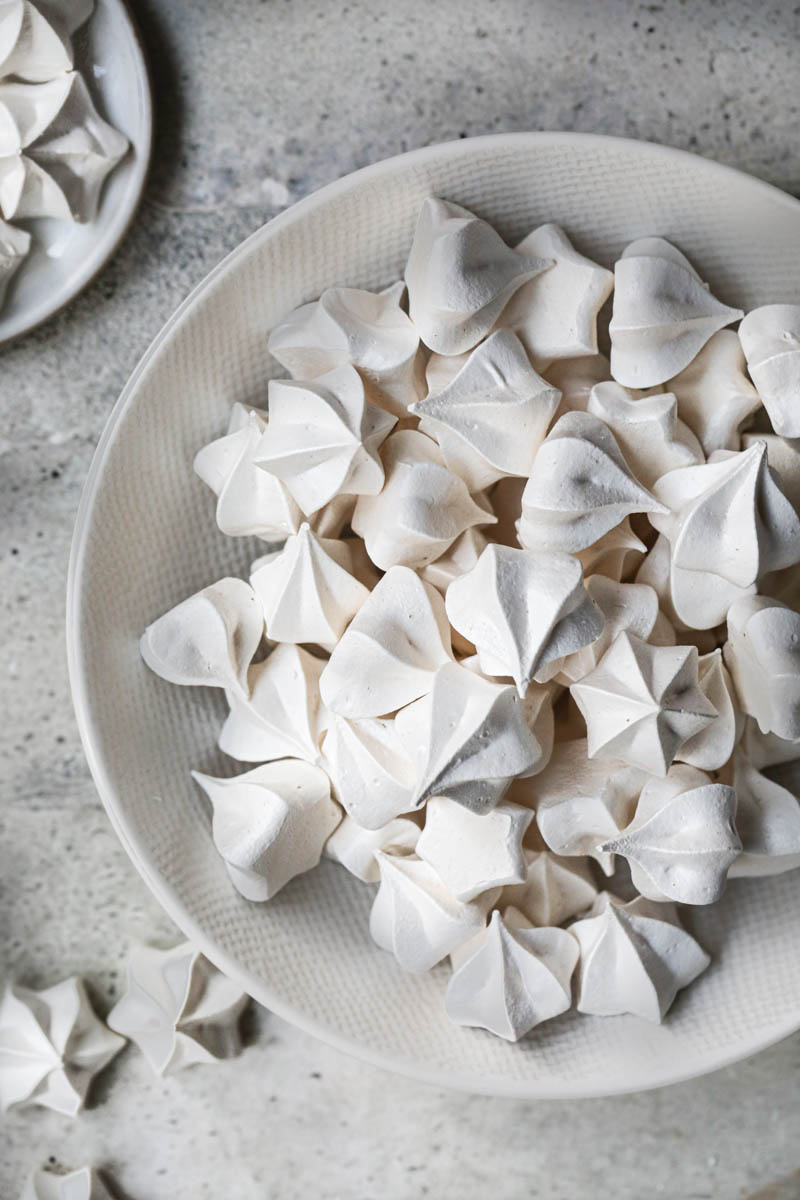 The Swiss meringue cookies inside a bowl with others on the side.