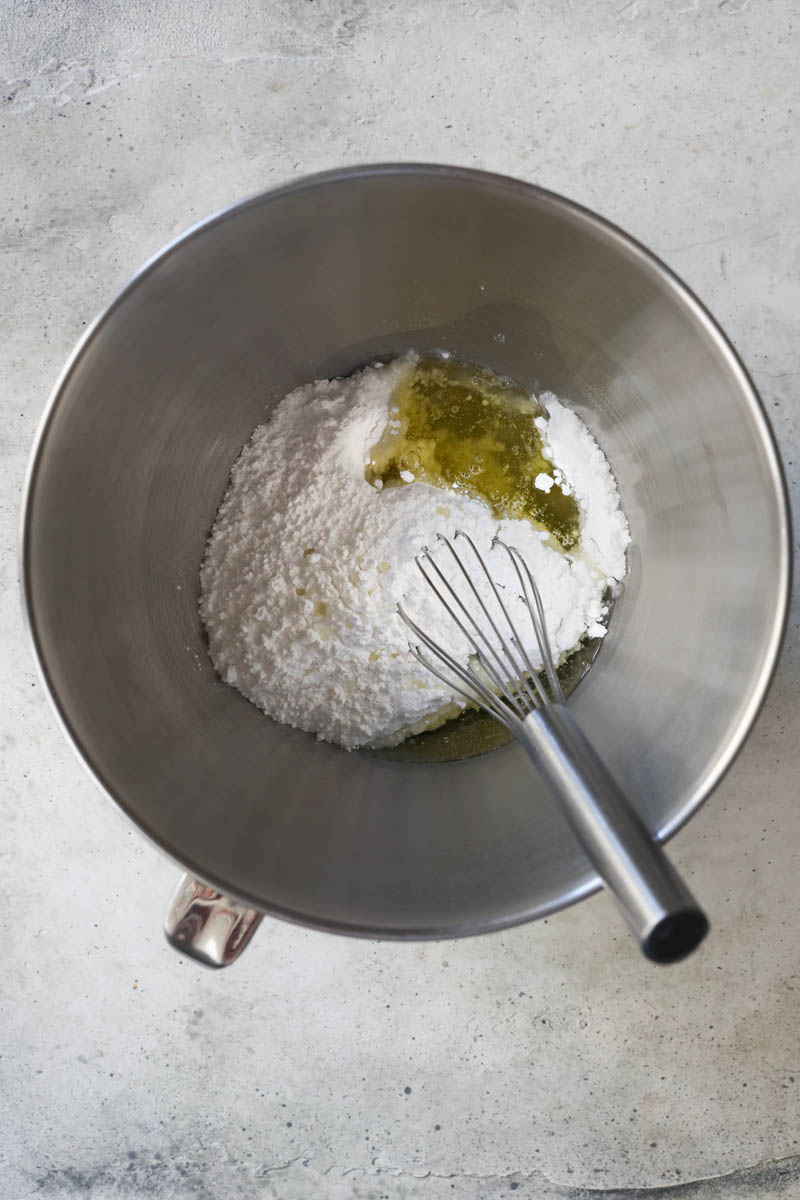 The egg whites and the sugar inside a mixing bowl.