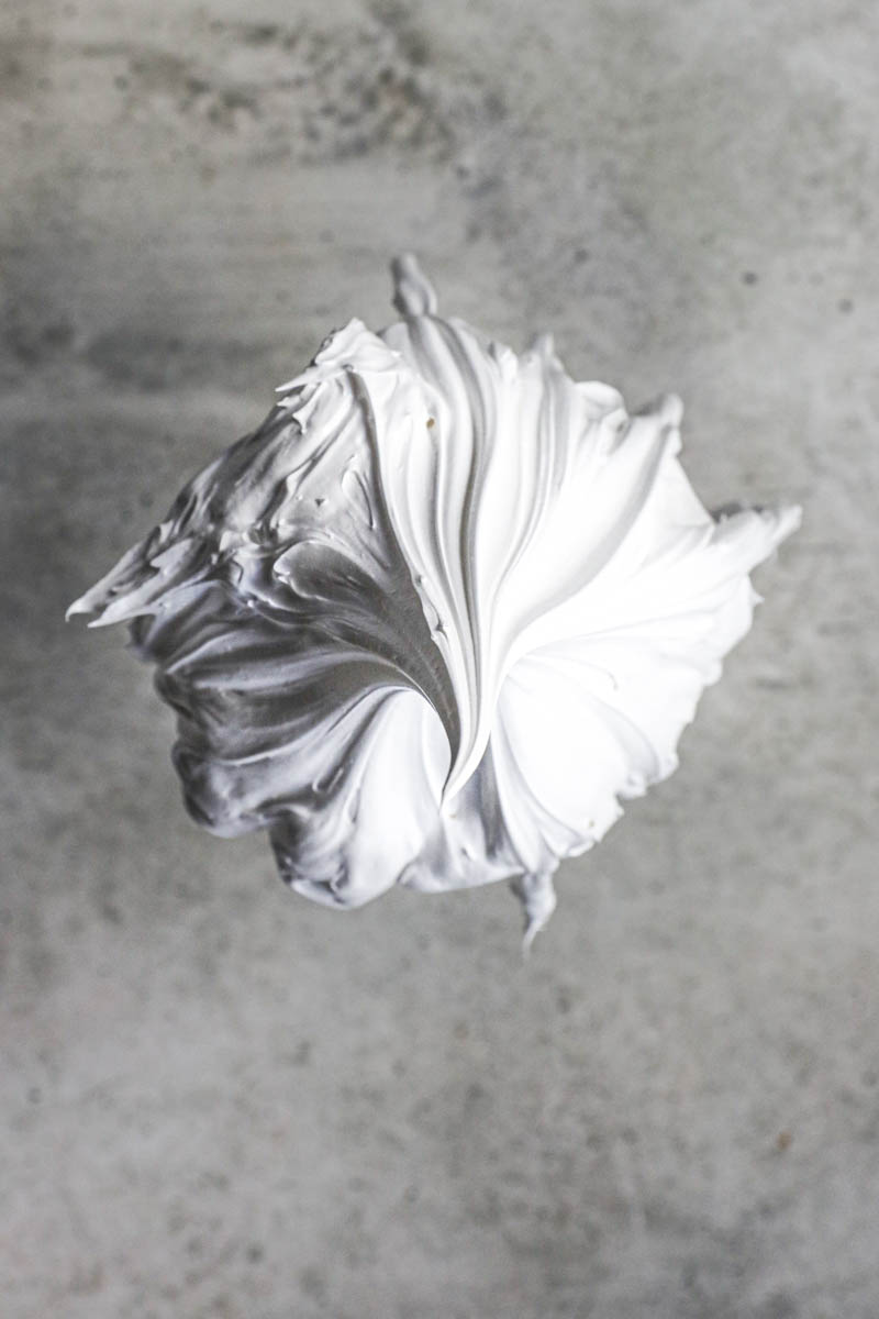 Closeup shot of the whisk holding the Swiss meringue as seen from above.