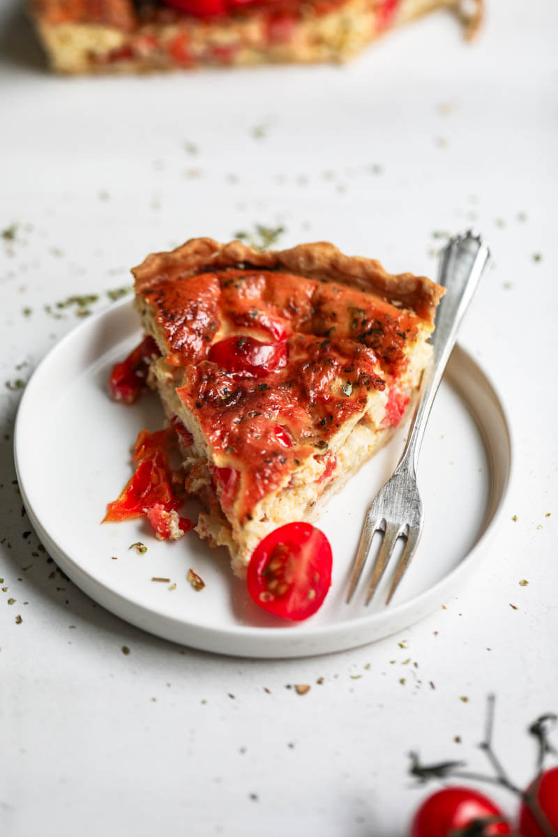 45° shot of one slice of tomato quiche on a plate