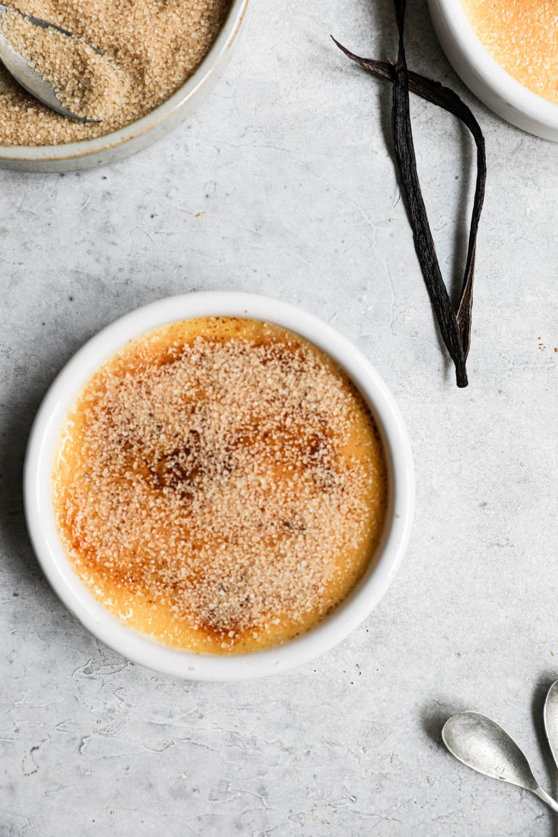 One round ramekin with vanilla crème brulee torched and sprinkled with a second layer of brown sugar.