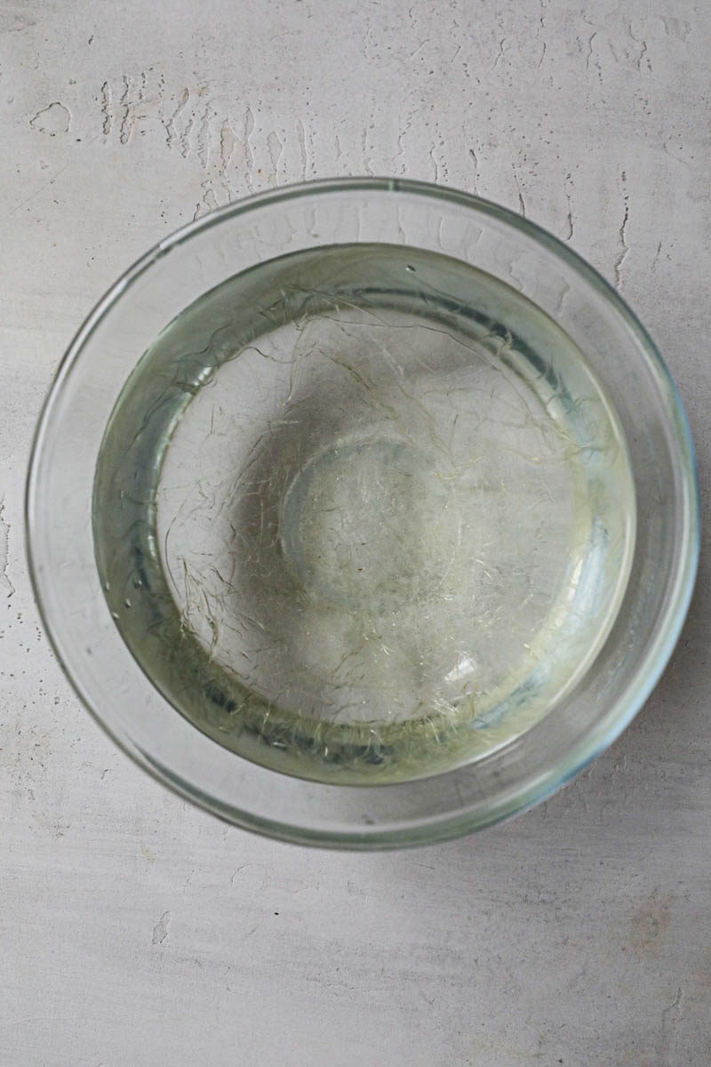Gelatine soaking in cold water in a glass bowl.