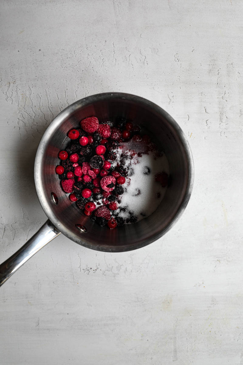 Berries and sugar inside a small pot.