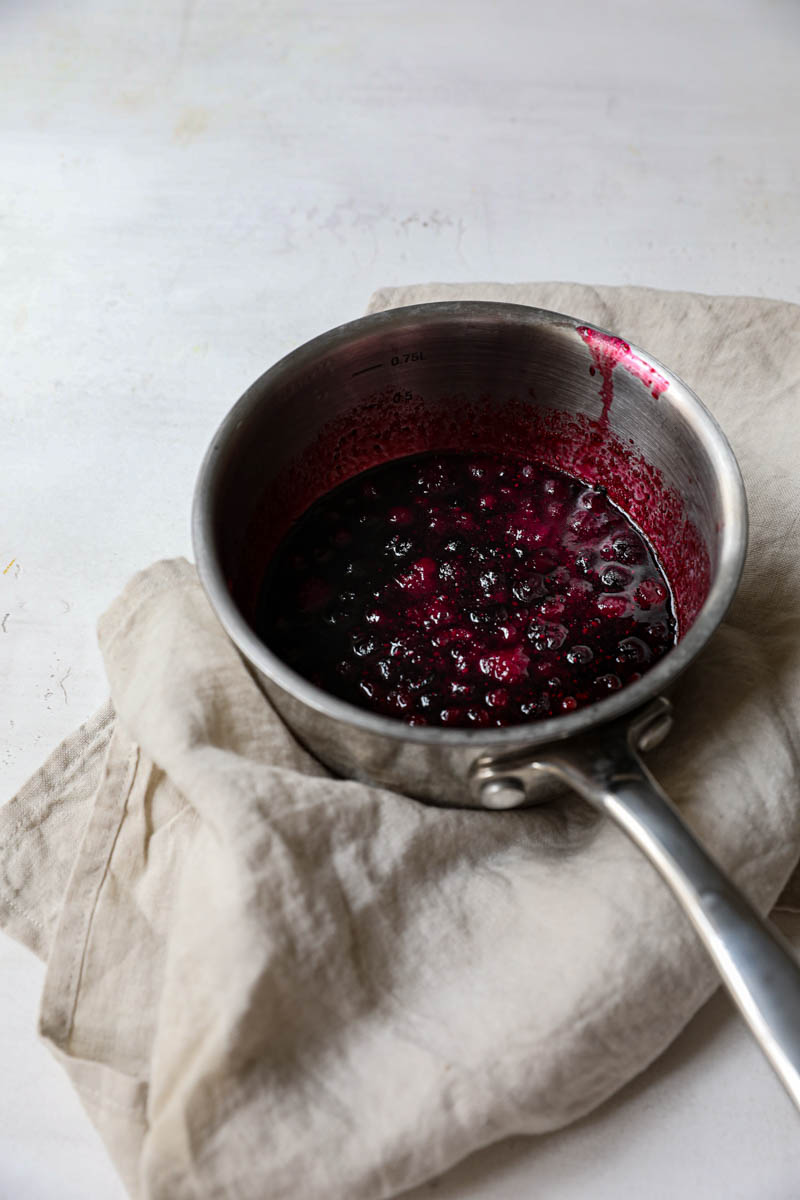 Berry sauce cooked inside a pot before straining.