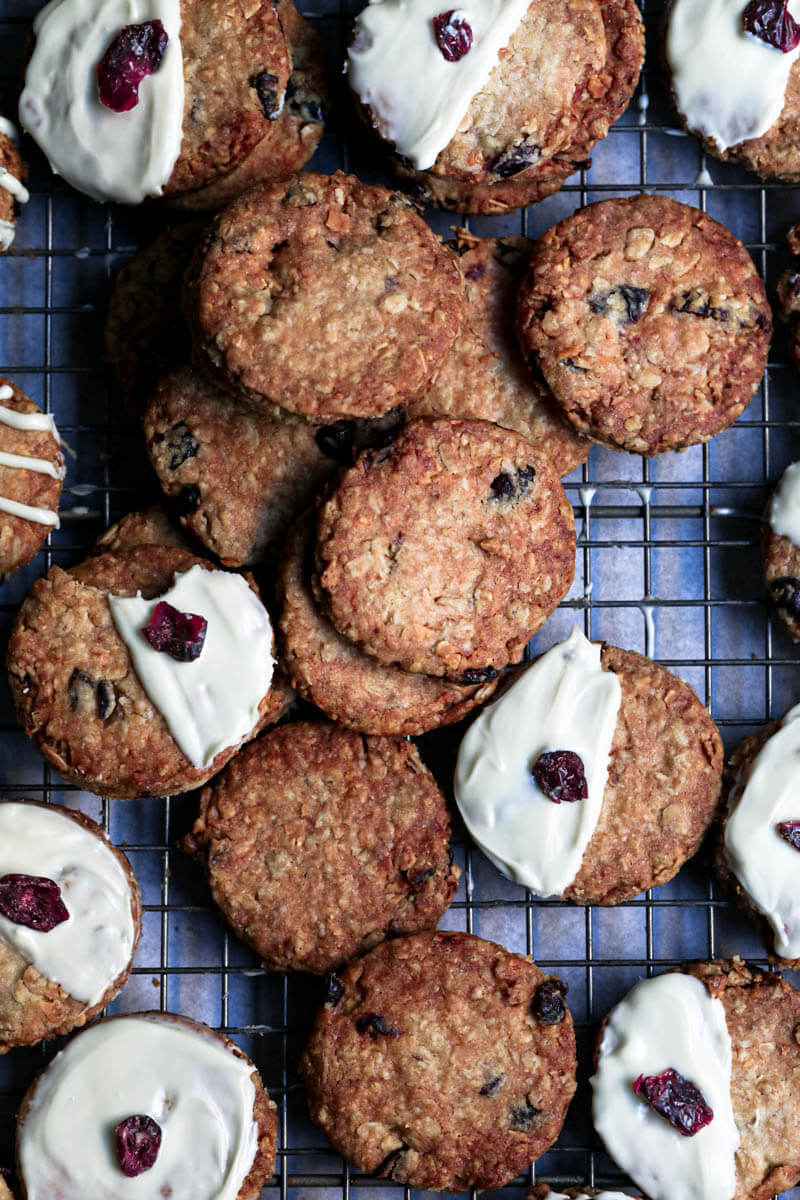 Many oatmeal cookies, some with white chocolate, some not on a wire rack