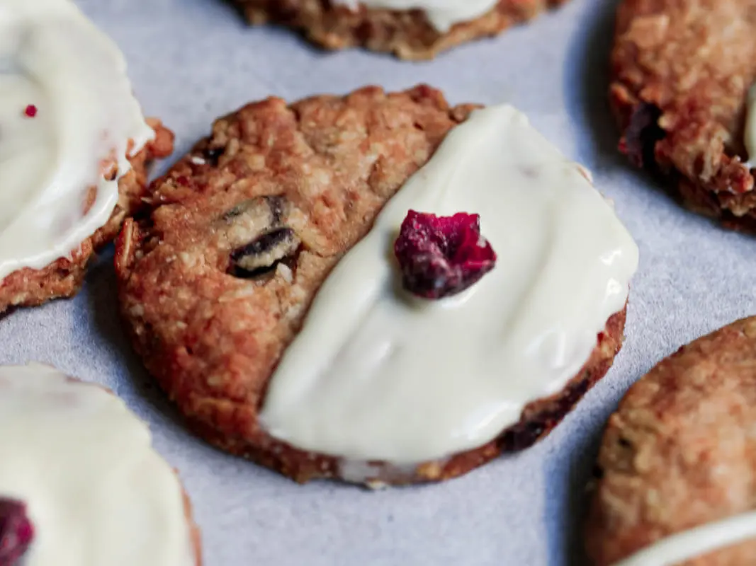 Oatmeal cranberry cookies frosted with white chocolate surrounded by other cookies
