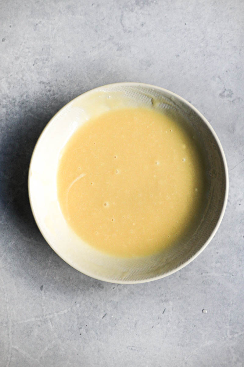 White chocolate ganache ready in a beige bowl.