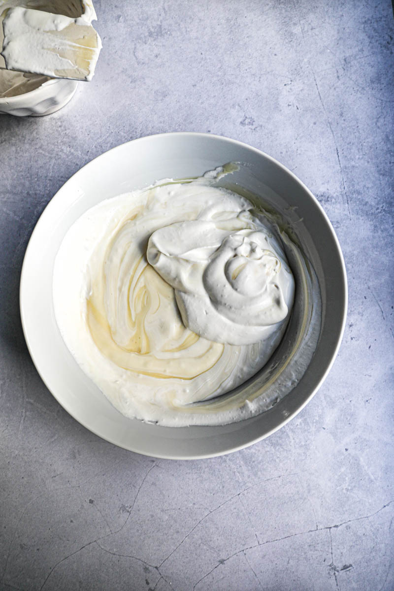 White chocolate ganache in a bowl with 1/3 of the whipped cream before folding it in.