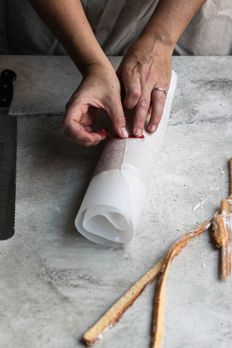 Two hands sealing the parchment paper with a piece of tape