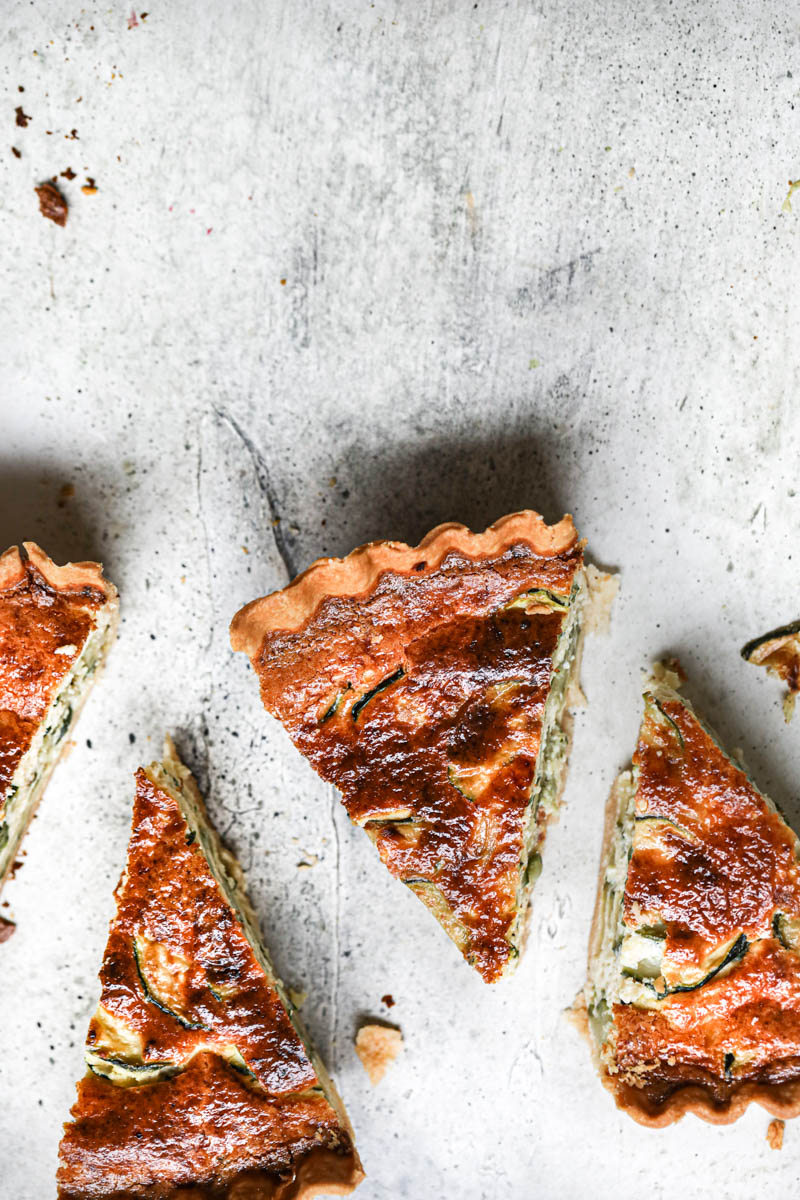 4 slices of zucchini quiche as seen from above placed in the bottom part of the frame.